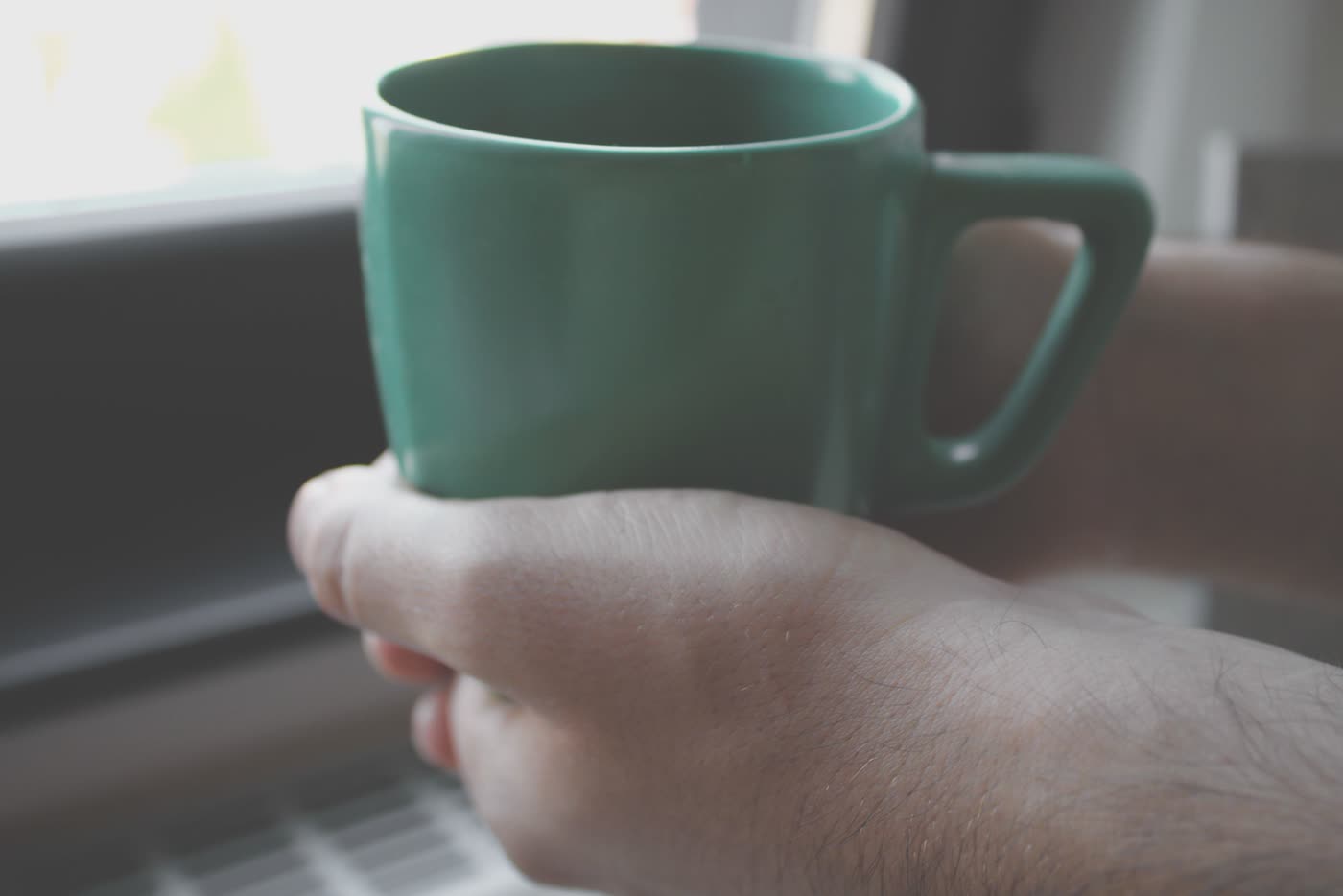 Hände halten einen Becher